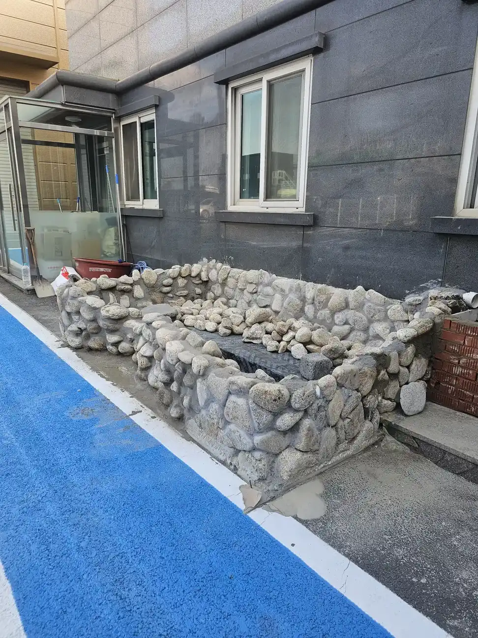 돌 쌓기가 끝난 연못 측면 건물 출입구 옆 시공 후